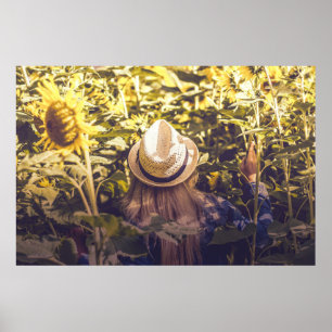 Person wearing white hat beside sunflower fields poster