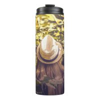 Person wearing white hat beside sunflower fields