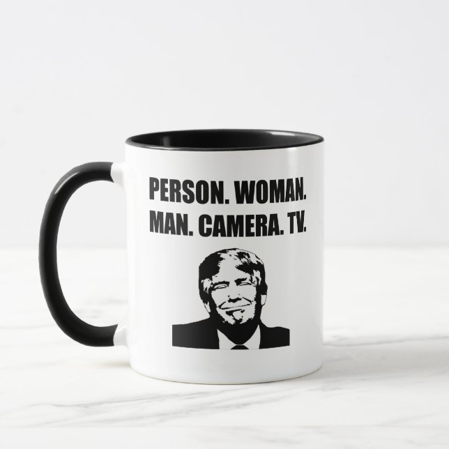 Person. Woman. Man. Camera. TV. Anti-Trump Mug (Left)