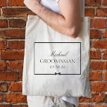 Personalised Classic Simple Bowtie Groomsman Tote Bag<br><div class="desc">Honour your groomsman with this sophisticated, customisable tote bag. Featuring a sleek black-and-white design, it highlights the groomsman’s name, title, and wedding date, framed by an elegant border and a stylish bow illustration. Ideal for carrying all the essentials on the big day, this tote blends seamlessly into any wedding theme,...</div>