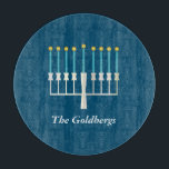 Personalised Family Name Blue Hanukkah Menorah Cutting Board<br><div class="desc">Celebrate Hanukkah with a modern twist using this deep blue design featuring a stylised menorah with glowing golden flames. The family name sits elegantly below in a refined serif font, adding a personal and festive touch. Perfect for holiday hosting, this design is ideal for families who value tradition, warmth, and...</div>