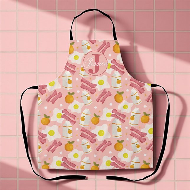 Personalised Retro Breakfast Pattern Apron (Whimsical pink apron with fried eggs, bacon, milk, and oranges for sunny breakfast vibes.)