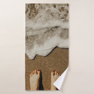 Person's feet on seashore bath towel