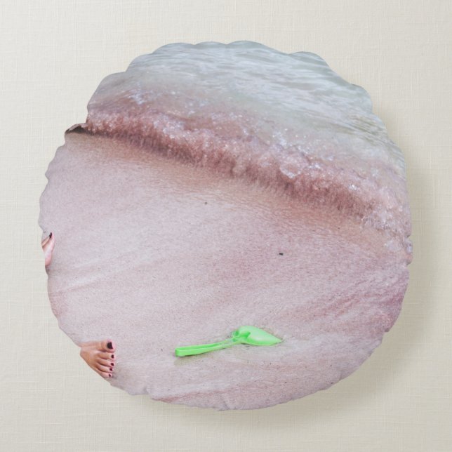 Person's foot beside green shovel on seashore round cushion (Front)