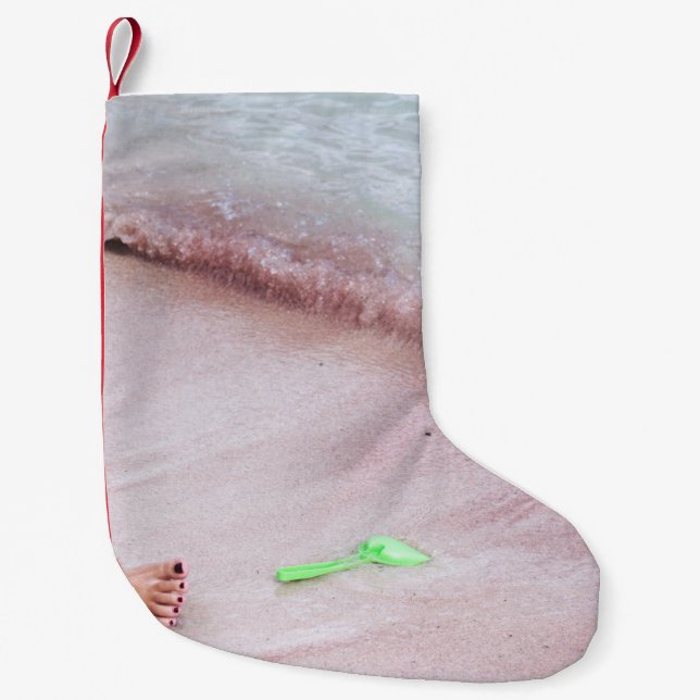 Person's foot beside green shovel on seashore small christmas stocking (Front)
