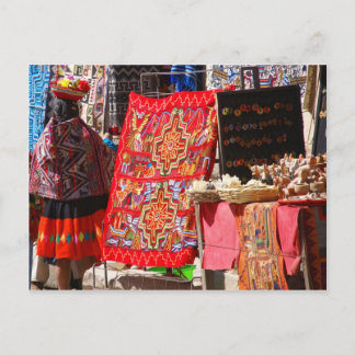 Peruvian Indian woman looking at colourful textile Postcard