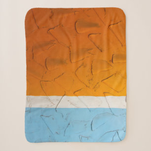 Photo of orange, white, and blue artwork sherpa blanket