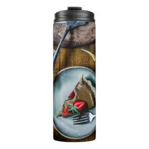 PIECE OF CAKE SERVED ON ROUND GRAY CERAMIC PLATE THERMAL TUMBLER