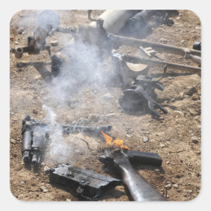Pieces of enemy weapons lay out to cool off square sticker