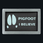 Pigfoot - I Believe Rectangular Belt Buckle<br><div class="desc">Maybe it is just a typo, or a mutant Sasquatch; or maybe some parts of the world are inhabited by another class of cryptid animals. A simple feral hog's footprint along with text reading, "PIGFOOT." Customisable text reading, "I BELIEVE" also appears. Who knows what out there running around in the...</div>