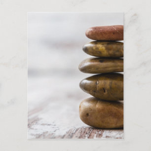 Pile of dark coloured stones on white background postcard