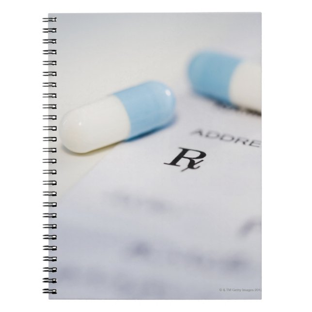 Pills on written prescription notebook (Front)