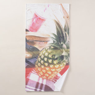 Pineapple beside phone and speaker bath towel