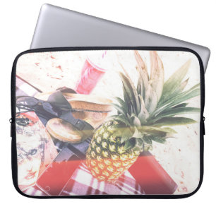 Pineapple beside phone and speaker laptop sleeve