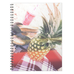 Pineapple beside phone and speaker notebook