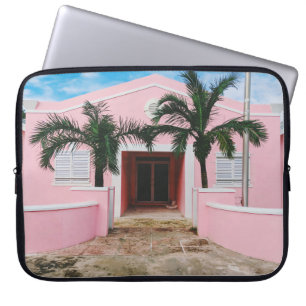 Pink and white concrete house near green trees und laptop sleeve