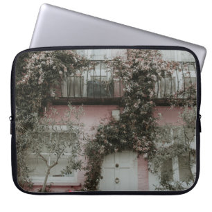 PINK AND WHITE PAINTED HOUSE COVERED WITH PLANTS A LAPTOP SLEEVE