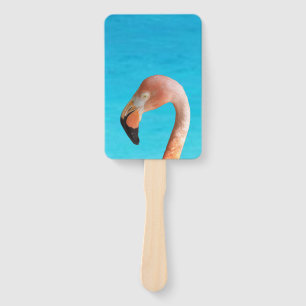 Pink flamingo face against blue water on a hand fan
