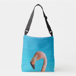 Pink flamingo face against blue water on crossbody bag