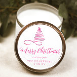Pink Ribbon Tree Merry Christmas Script Classic Round Sticker<br><div class="desc">This modern holiday sticker features a shiny pink ribbon in the shape of a Christmas tree and the words "Merry Christmas" in stylish pink calligraphy script. Personalise it with your family's name in serif font.</div>