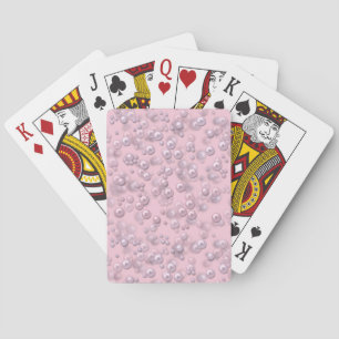Placers of white-pink pearls on pink velvet playing cards