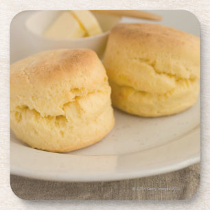 Plain scone with butter on plate coaster
