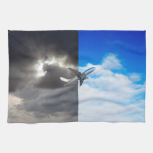 Plane flying out of stormy sky into blue sky tea towel
