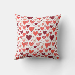 Playful hand drawn red hearts pattern on white cushion
