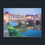 Ponte Vecchio Florence Italy Postcard<br><div class="desc">The Ponte Vecchio ("Old Bridge", Italian pronunciation: [ˈpɔnte ˈvɛkkio])[1] is a Mediaeval bridge over the Arno River, in Florence, Italy, noted for still having shops built along it, as was once common. Butchers initially occupied the shops; the present tenants are jewelers, art dealers and souvenir sellers. It has been described...</div>