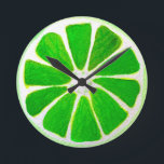 Pop art bright lime fruit original watercolour round clock<br><div class="desc">A cute and colorful vibrant green lime fruit slice from an original painting by artist Sacha Grossel. This large pop art style fruit is green and very bright and colorful against a customizable orange colored background. Quirky and original.</div>