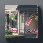 Porch & American Flag photo Plaque<br><div class="desc">Enjoy an original colour photo of the American flag. Red, white, & blue bunting along with ferns on the front porch of a vintage home. Fun, patriotic, distinctive, & appealing! For yourself or great as a gift! Plaque with Easel for this original photo of mine. Enjoy! Thank you, from Jay....</div>