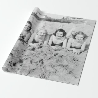 Portrait of five young women lying on the beach an wrapping paper