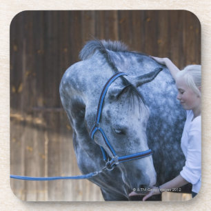 portrait of young girl holding white horse coaster