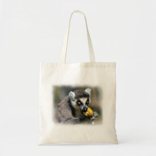 Portrait ring-tailed lemur eating a banana tote bag