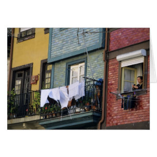 Portugal, Oporto (Porto). Woman hanging laundry