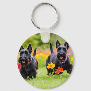 Prancing Scottish Terriers in grass and flowers Key Ring
