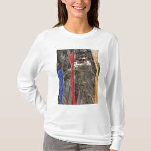 Prayer flags hang near Taktshang T-Shirt