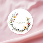Pretty Wildflowers Wedding Wreath Names and Date Classic Round Sticker<br><div class="desc">Add a fresh, romantic touch to your wedding favours or stationery with these Pretty Wildflowers Wedding Wreath Names and Date Sticker. This elegant round sticker features a delicately illustrated wreath of pretty wildflowers in vibrant summer hues red, yellow, and green with leafy accents that evoke a lush garden in full...</div>