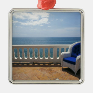 Puerto Rico. Wicker chair and tiled terrace at Metal Tree Decoration