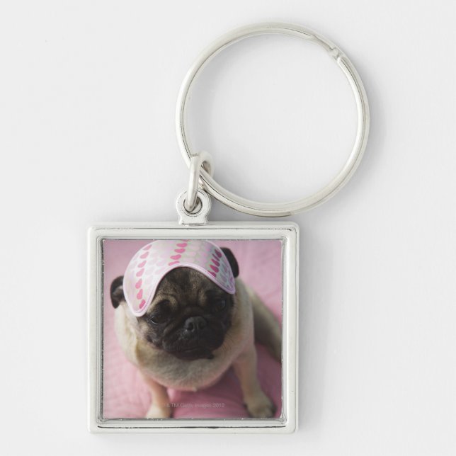 Pug dog with eye mask on head sitting on bed, key ring (Front)
