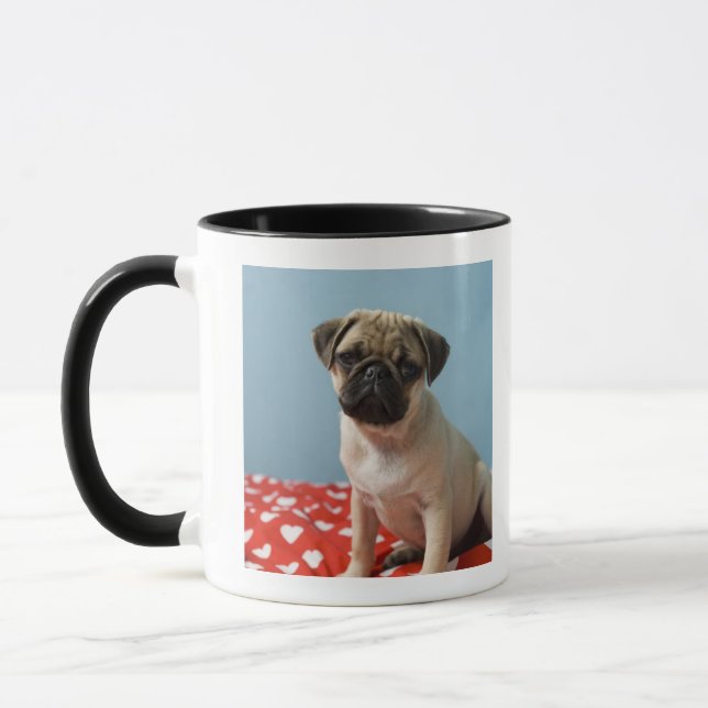 Pug puppy sitting on bed mug (Left)