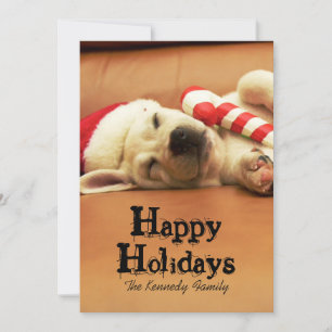 Puppy sleeps on sofa with christmas toys holiday card