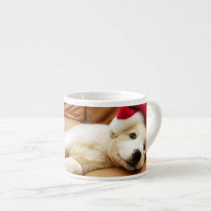 Puppy wears a christmas hat and lying on sofa espresso cup