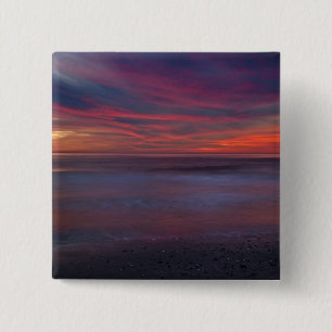 Purple-coloured sunrise on ocean shore 15 cm square badge
