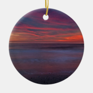 Purple-coloured sunrise on ocean shore ceramic ornament