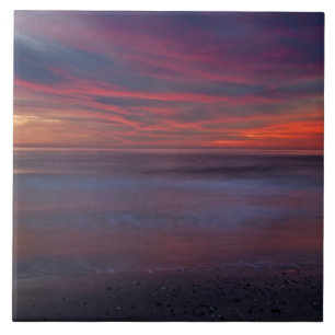 Purple-coloured sunrise on ocean shore ceramic tile