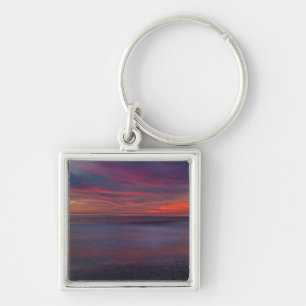 Purple-coloured sunrise on ocean shore key ring