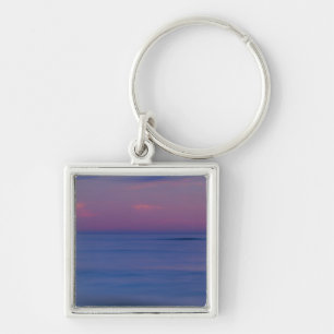 Purple-coloured sunrise on ocean shore key ring