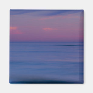 Purple-coloured sunrise on ocean shore magnet
