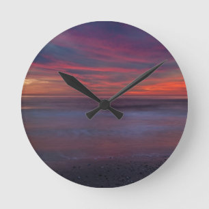 Purple-coloured sunrise on ocean shore round clock